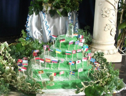 A cake in the shape of the Tor, covered in world flags